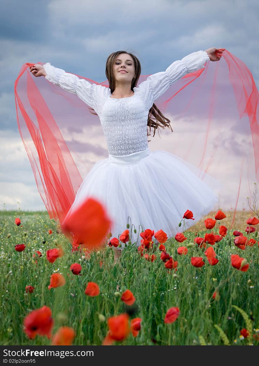 Young happy girl with red veil in field. Young happy girl with red veil in field