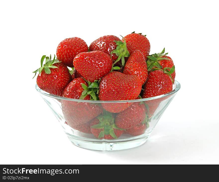 Fresh and juicy strawberries on glass bowl over white