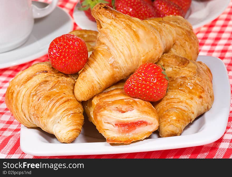 Fresh croissants and strawberry with cup of coffee