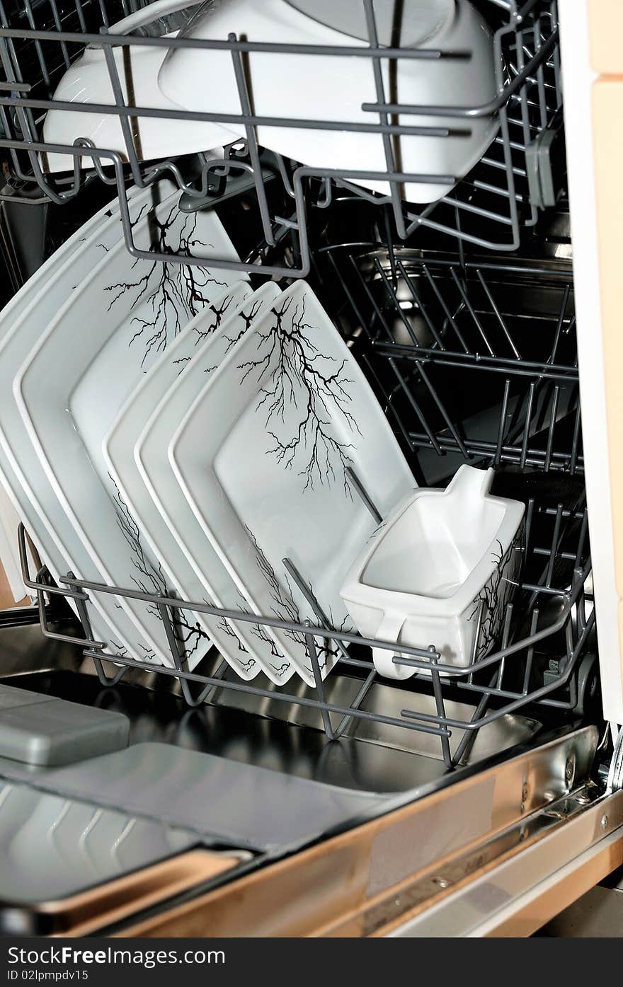 Close up of an open dishwasher with plates