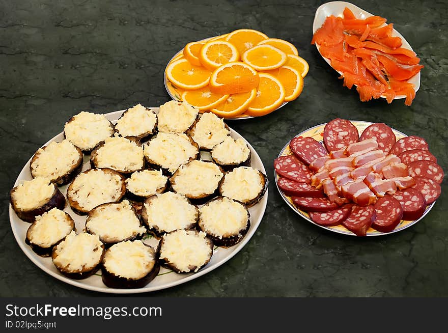 Still-life from four dishes. Orange, meat, fish.