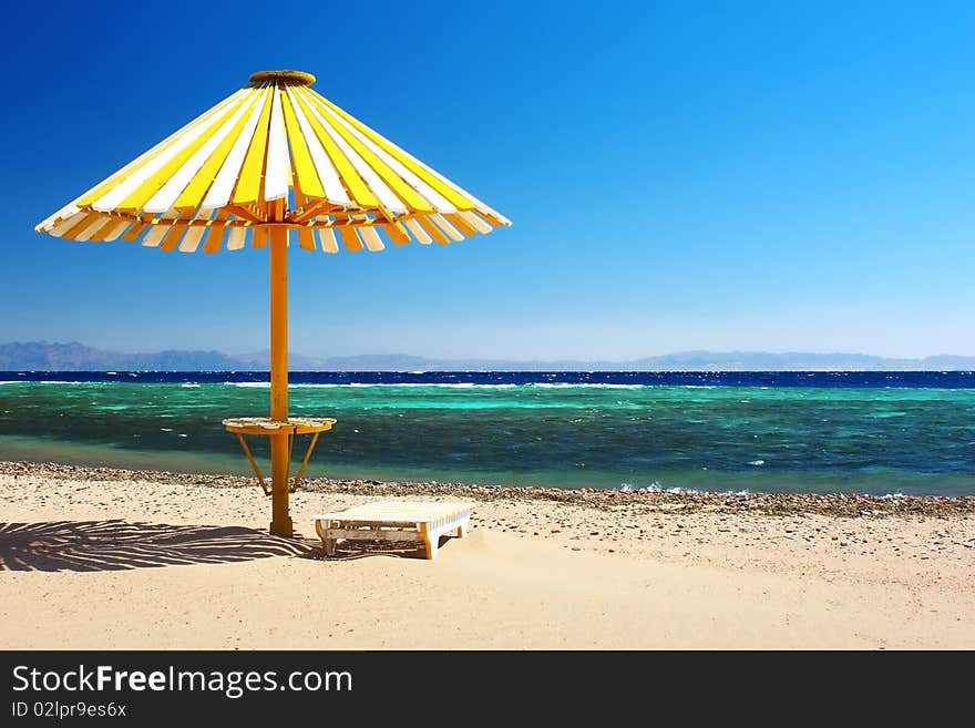 Wood umbrella on beach with clear blue sky