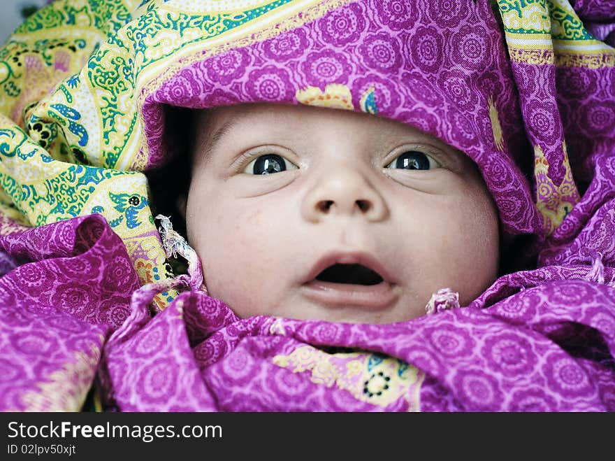 The surprised and happy baby in red cloak