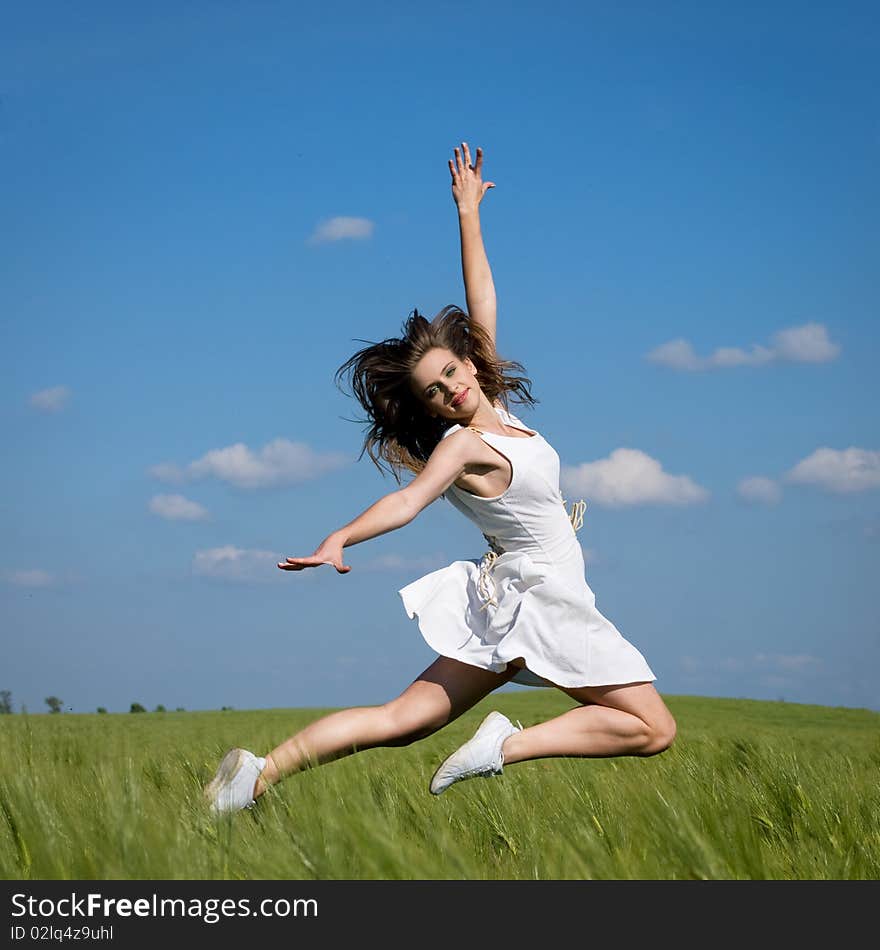 Young happy girl jumping in green field. Young happy girl jumping in green field