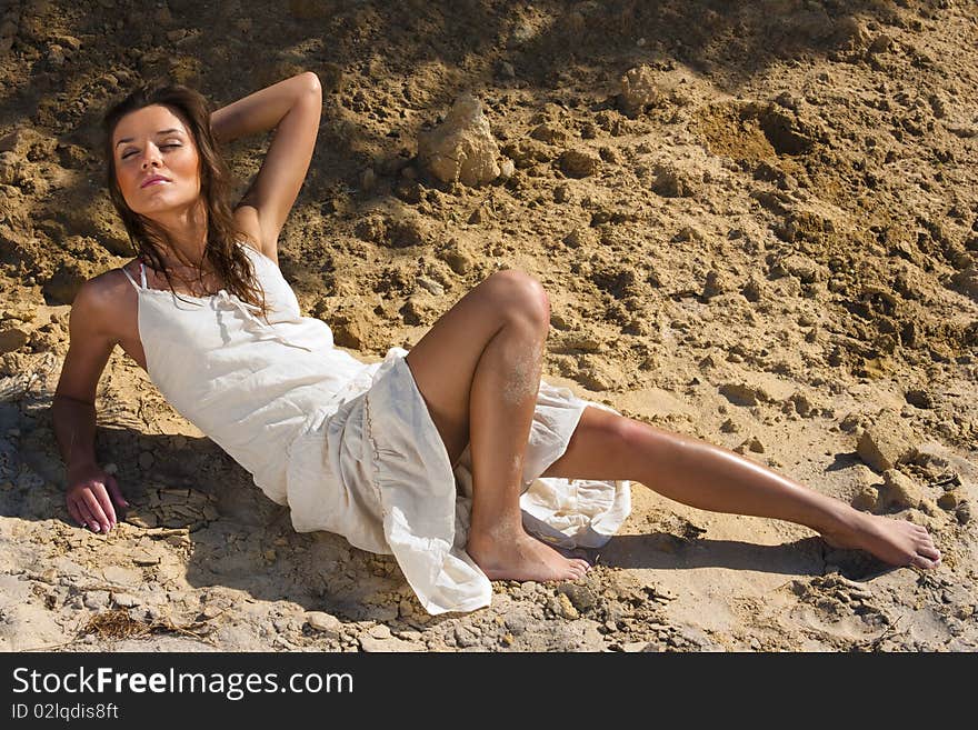 Young woman in white dress against the cliff