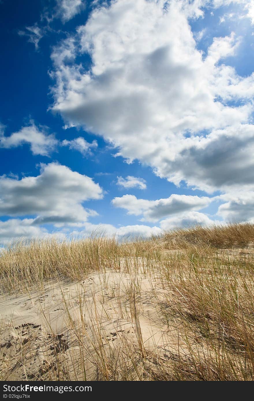 Sand dunes near to the sea with cloudy sky