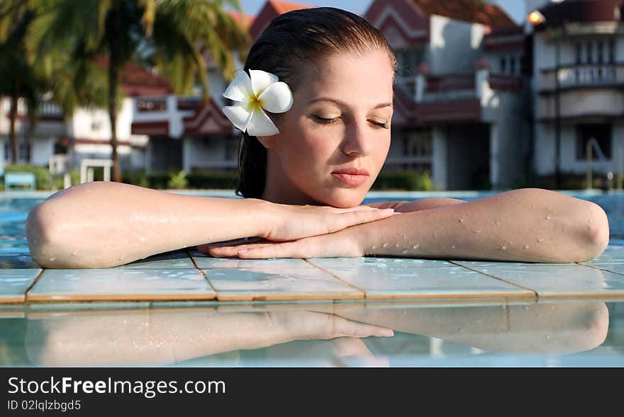 Young beautiful woman with flower in swimming pool. Young beautiful woman with flower in swimming pool