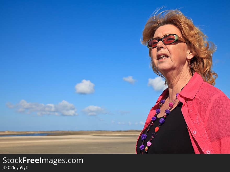 Red haired woman looking to the sea on a sunny day