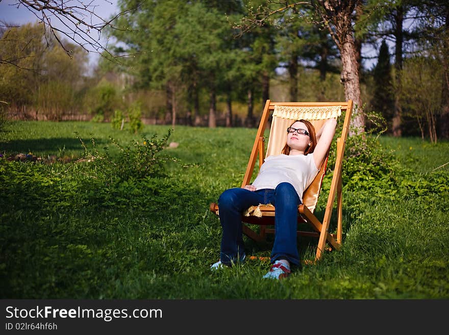 Pregnant girl in chair in garden. Pregnant girl in chair in garden