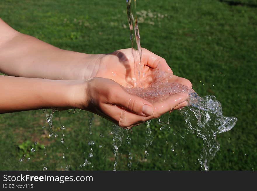 The hands of a young girl and a jet of water