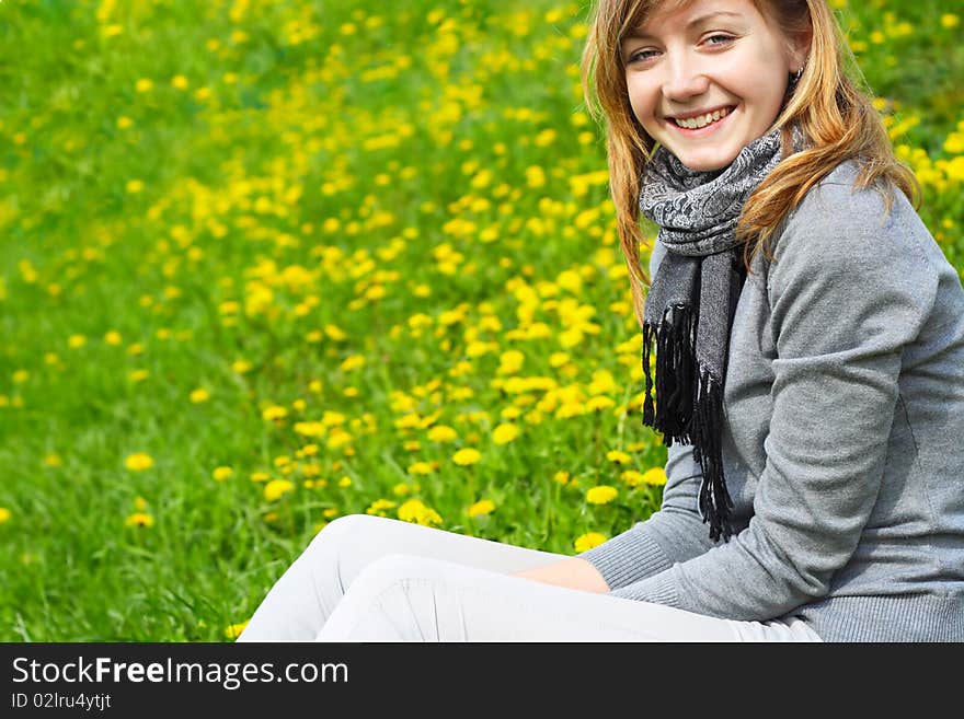 The girl sits on a grass