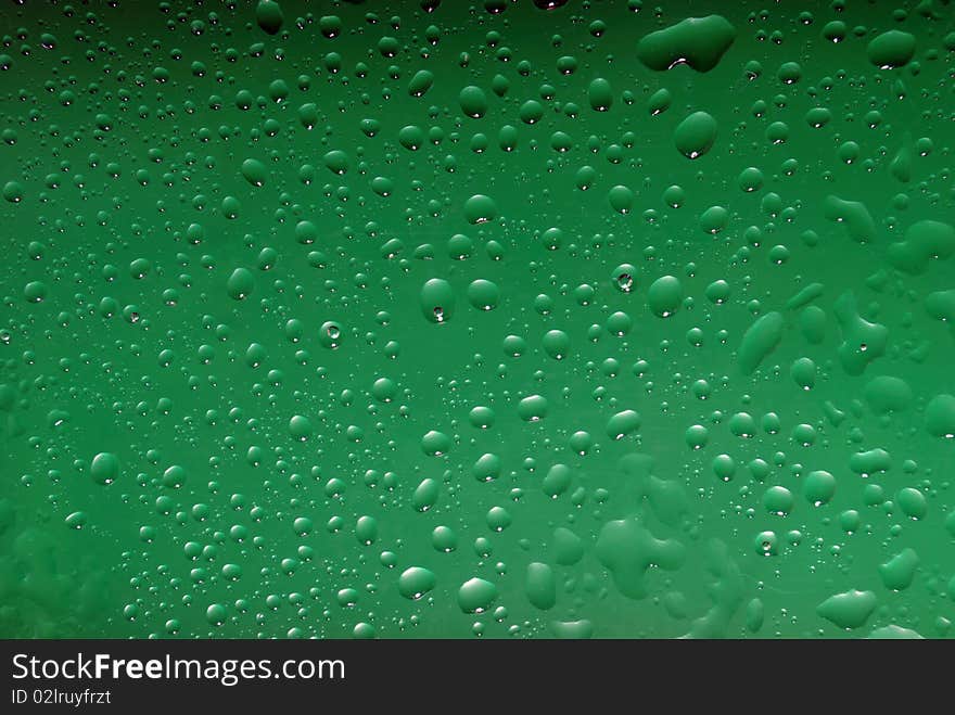 Drops from water on green colour of a background