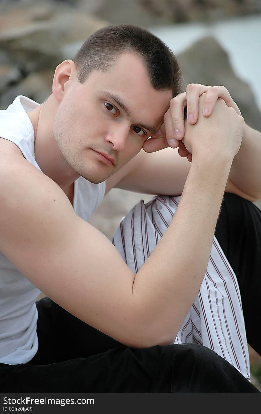 Man with piercing eyes цith dark hair in a white T-shirt