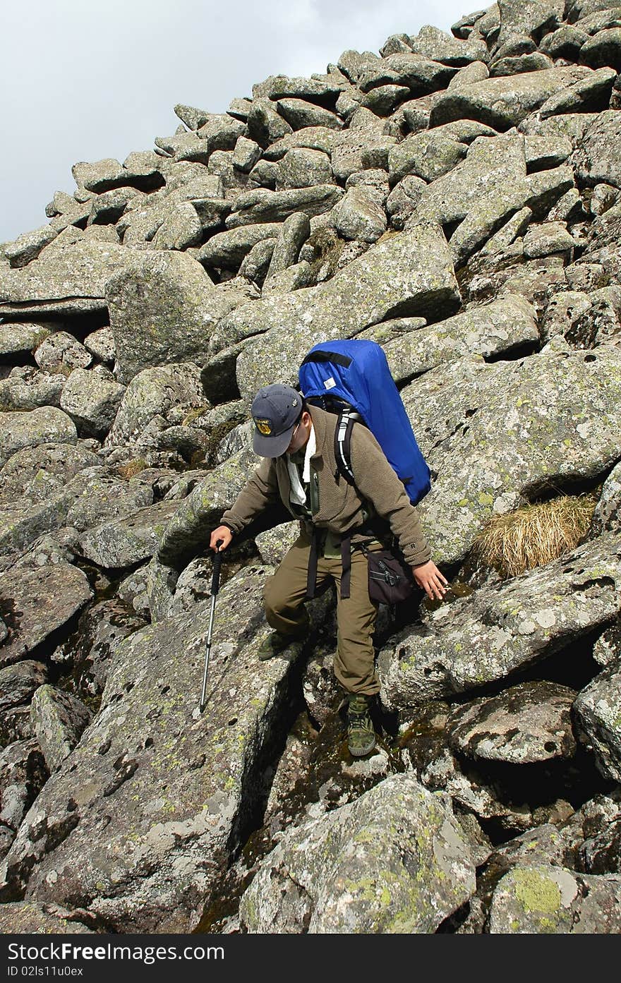 A backpacker trekking in the sea of rocks. A backpacker trekking in the sea of rocks