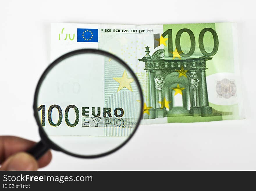 One hundred euro with magnifying glass on white background. One hundred euro with magnifying glass on white background