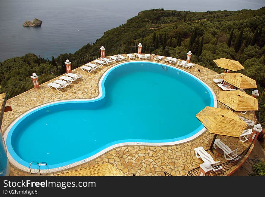 Outside swimming pool in hills overhanging the Ionian Sea on the coast of the island of Corfu, Greece. Outside swimming pool in hills overhanging the Ionian Sea on the coast of the island of Corfu, Greece.