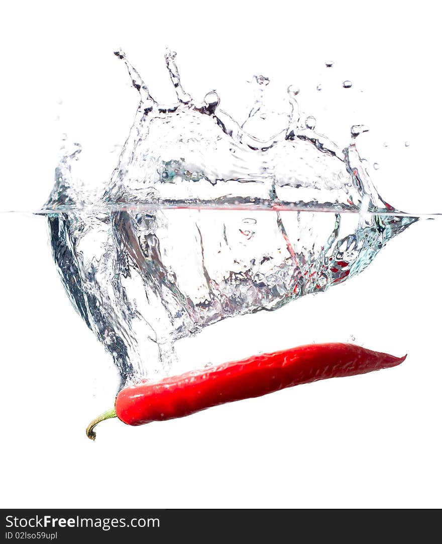 Red hot chili pepper splashing into water isolated on white. Red hot chili pepper splashing into water isolated on white