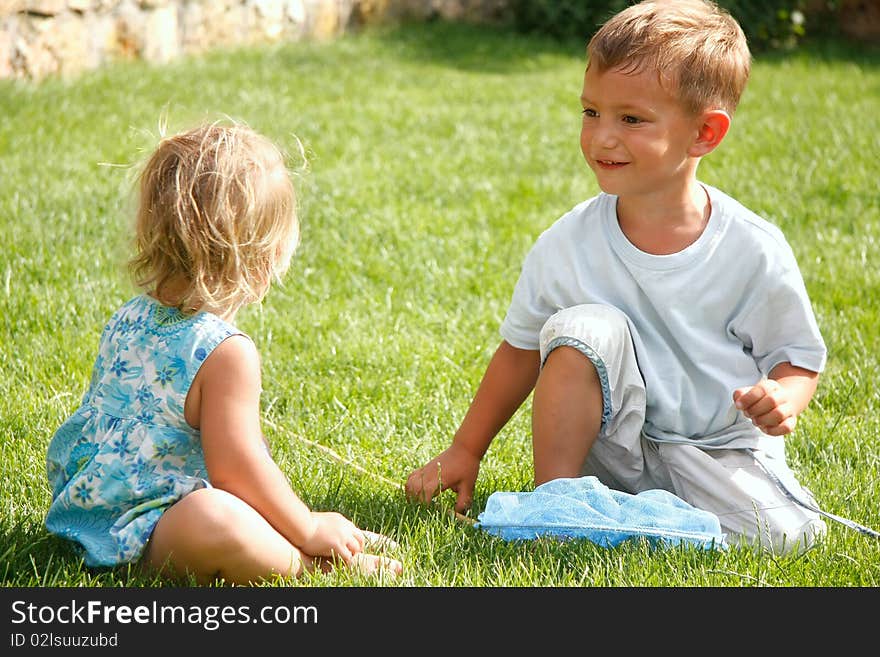 Two kids playing on green grass