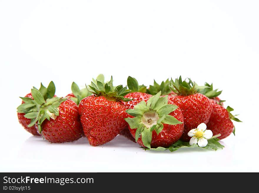 Strawberries with a leaf and a flower on white background