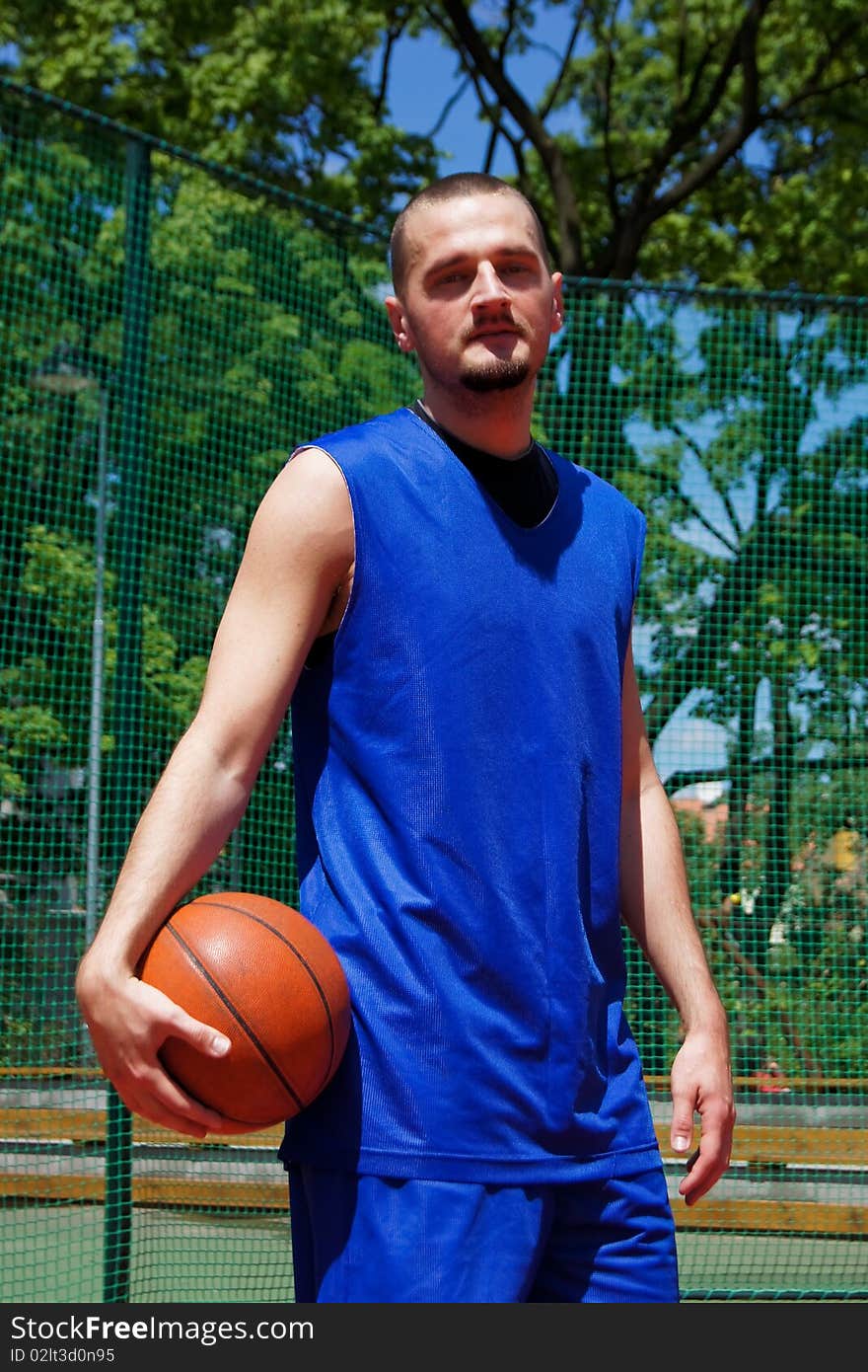 Young basketball player with ball on the sportground