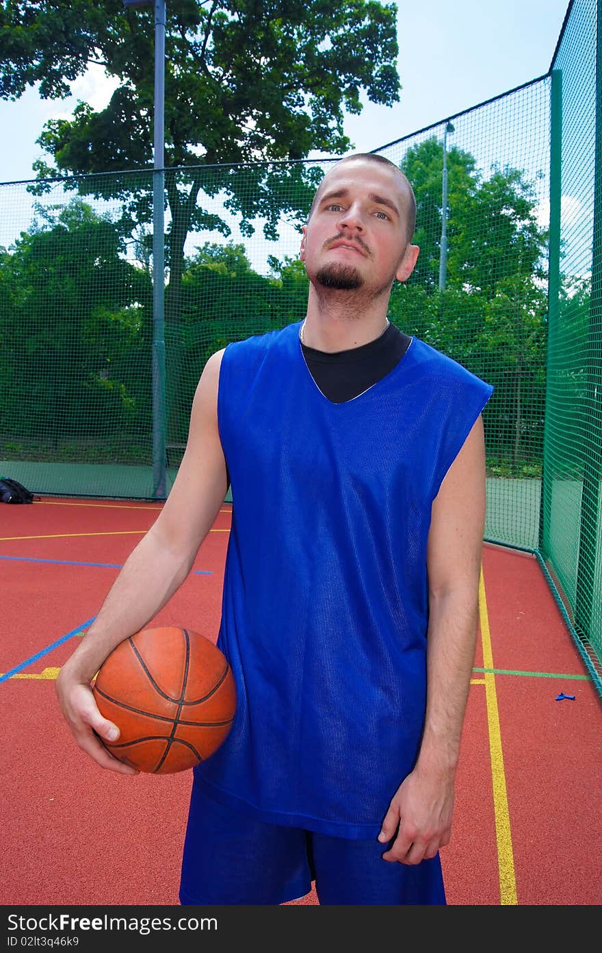 Young basketball player with ball on the sportground