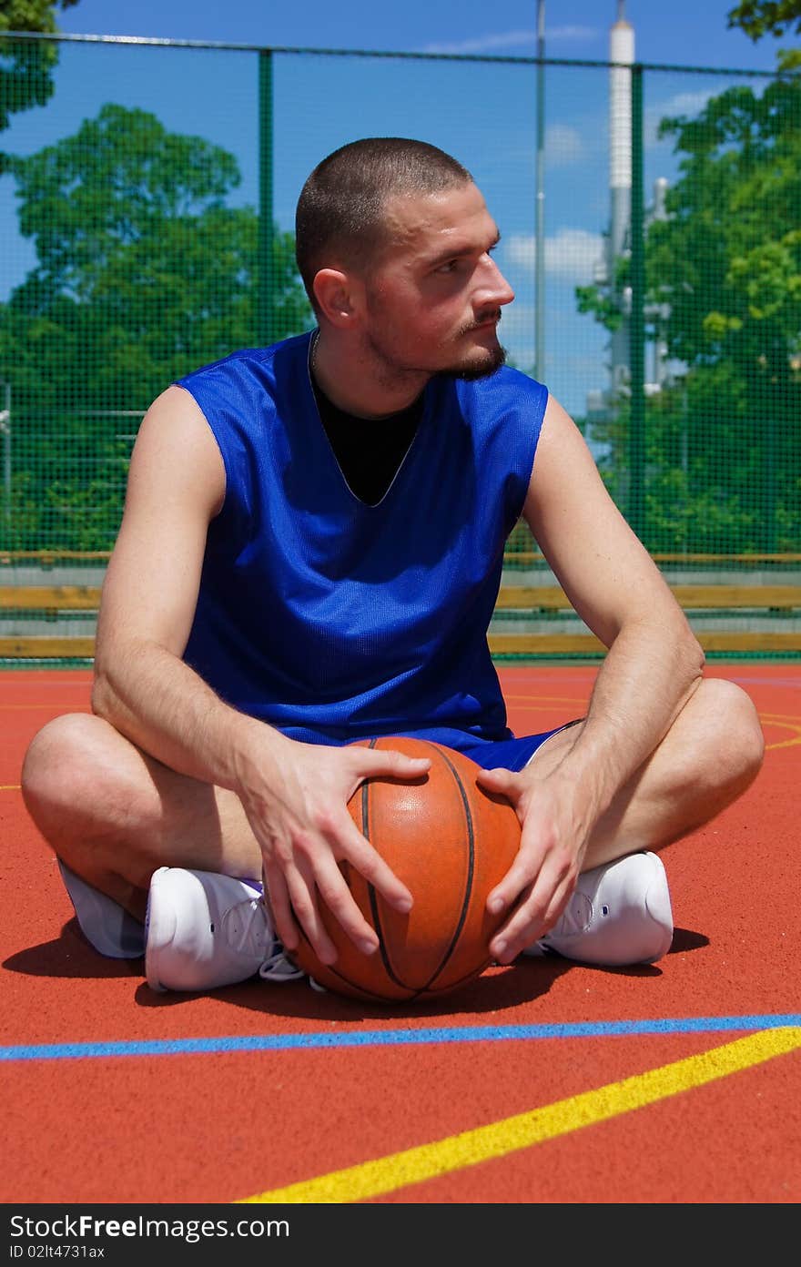 Young basketball player with basketball ball on the sportground with look left. Young basketball player with basketball ball on the sportground with look left