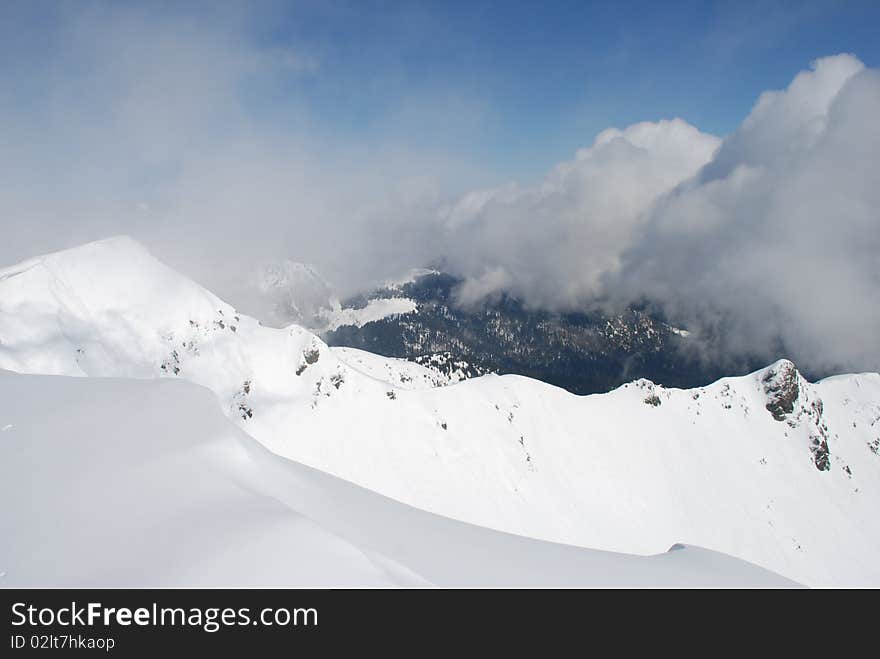 Mountain winter slope in clouds.