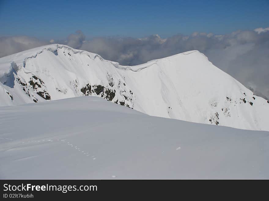 Mountain winter slope in clouds.