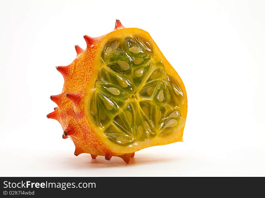 Horned melcon, also known as Blowfish Fruit, cut in half showing green pulp and seeds on a white background. Horned melcon, also known as Blowfish Fruit, cut in half showing green pulp and seeds on a white background.