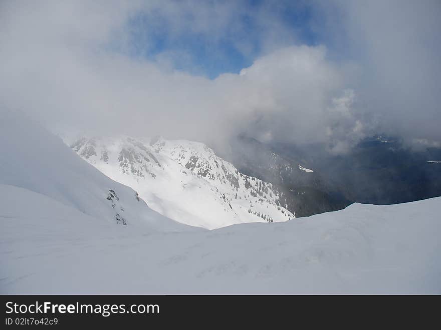 Mountain winter slope in clouds.