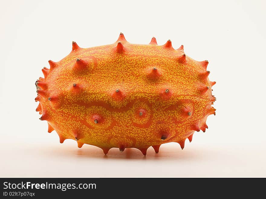 Whole horned melon, also known as Blowfish Fruit, on white background.