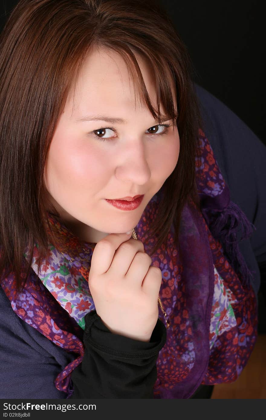 Headshot of beautiful brunette female on a black background