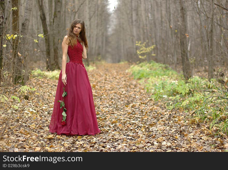 Girl with rose in the forest