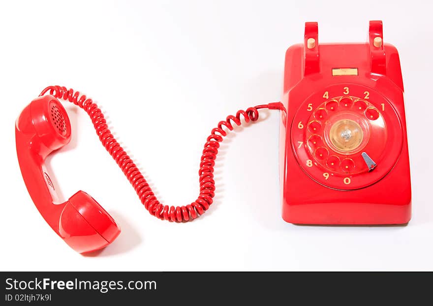 Classic 1970 - 1980 retro dial style red house telephone on white background