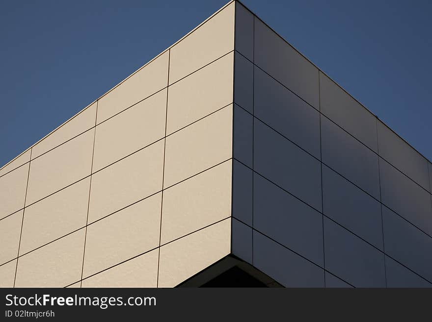 Closeup of white wall at angle against a blue sky background. Closeup of white wall at angle against a blue sky background