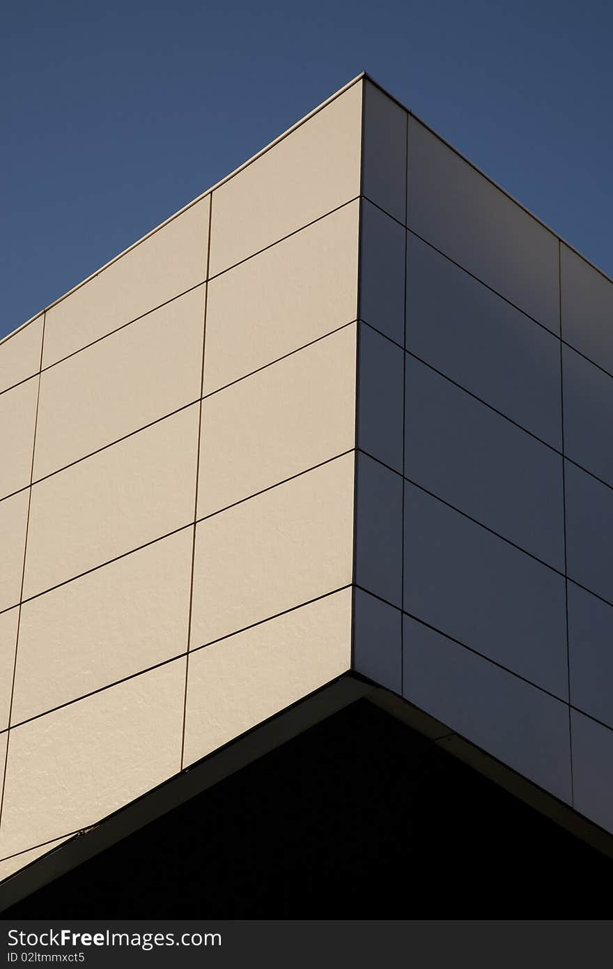 Vertical closeup of white wall at angle against a blue sky background. Vertical closeup of white wall at angle against a blue sky background