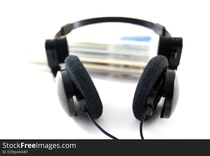 Headphones and compact disks on white background