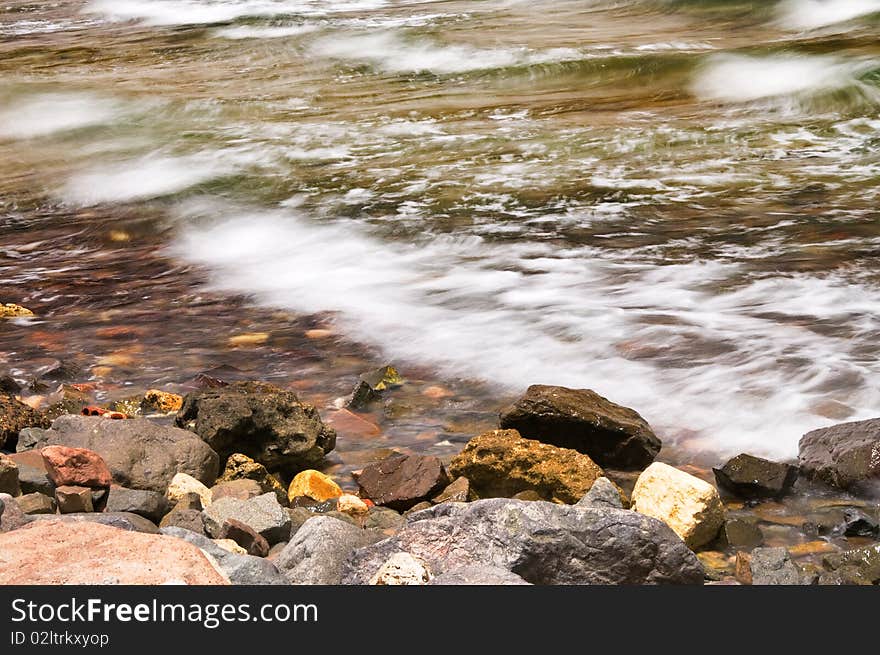 Sea foam and pebble in the water. Sea foam and pebble in the water.