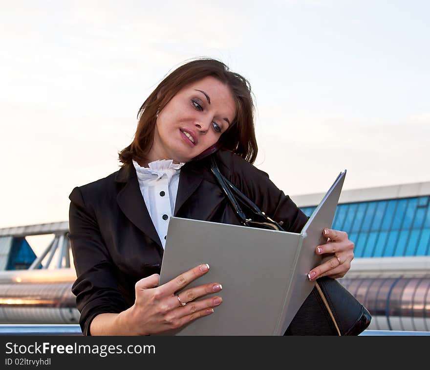 Young business lady speaking over the mobile phone in the big city background