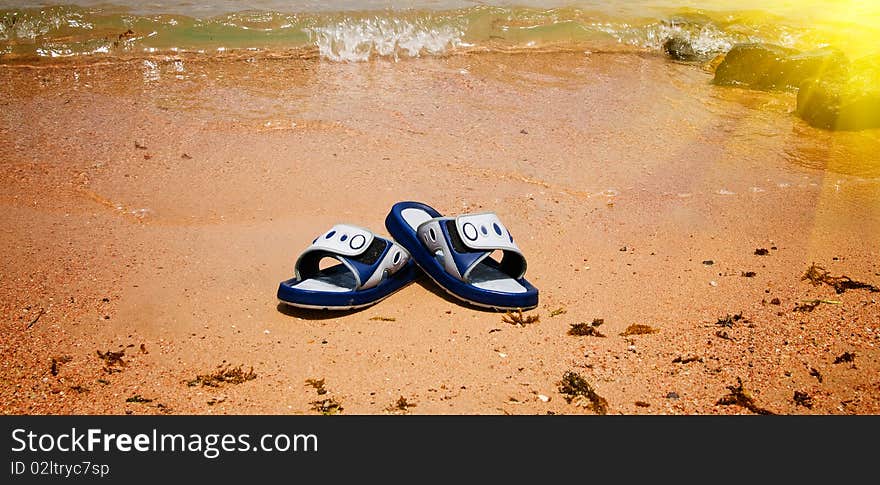 Wet sandals next to the sea.