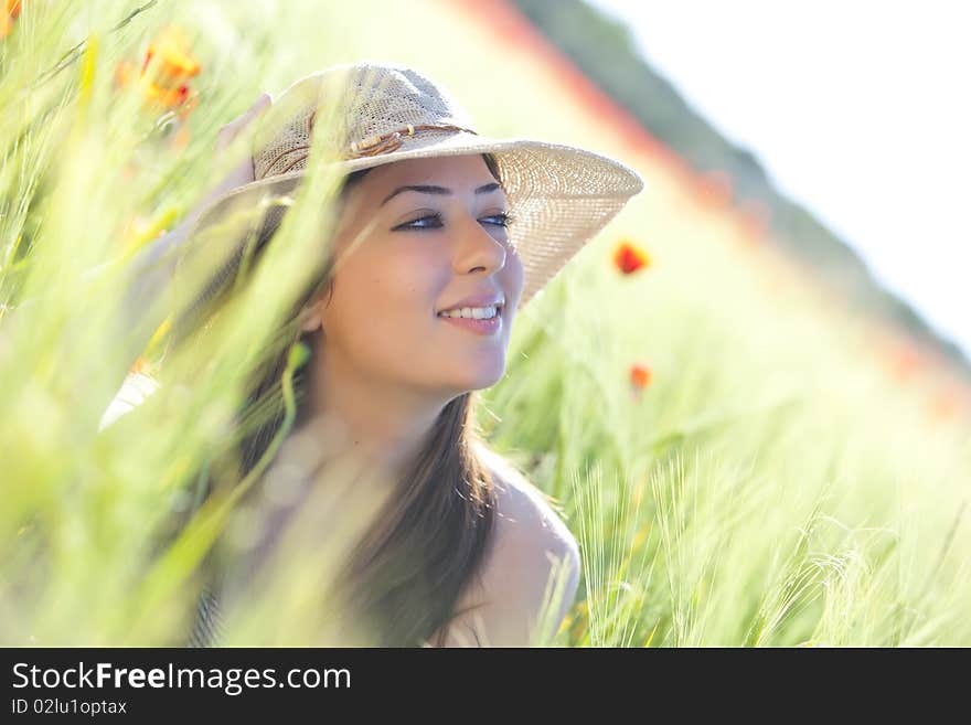 Young beautiful girl with hat staring and smiling at something. Young beautiful girl with hat staring and smiling at something