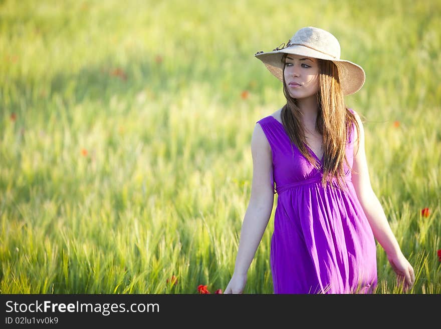 Young beautiful girl posing in a green field. Young beautiful girl posing in a green field.