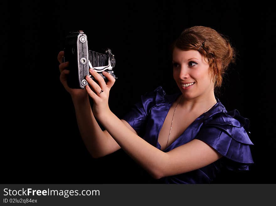 Beautiful woman with the old camera on a black background. Beautiful woman with the old camera on a black background