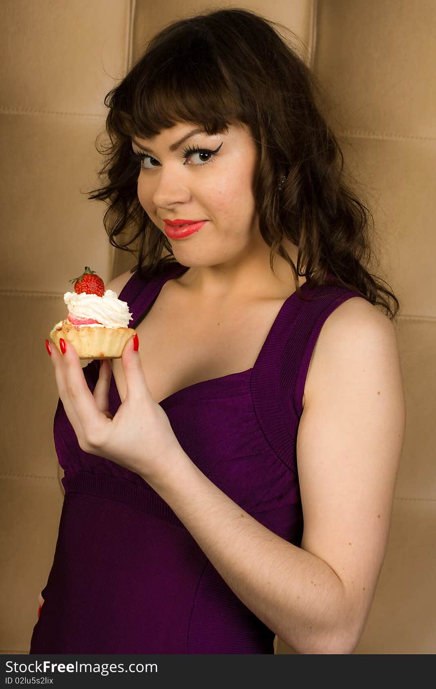 girl in violet dress is eating cake. girl in violet dress is eating cake