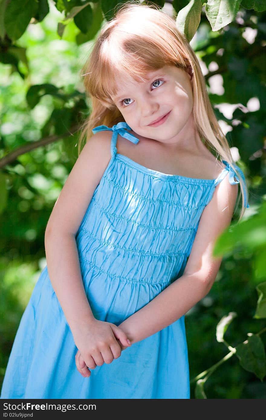 Little girl in the park wearing blue dress