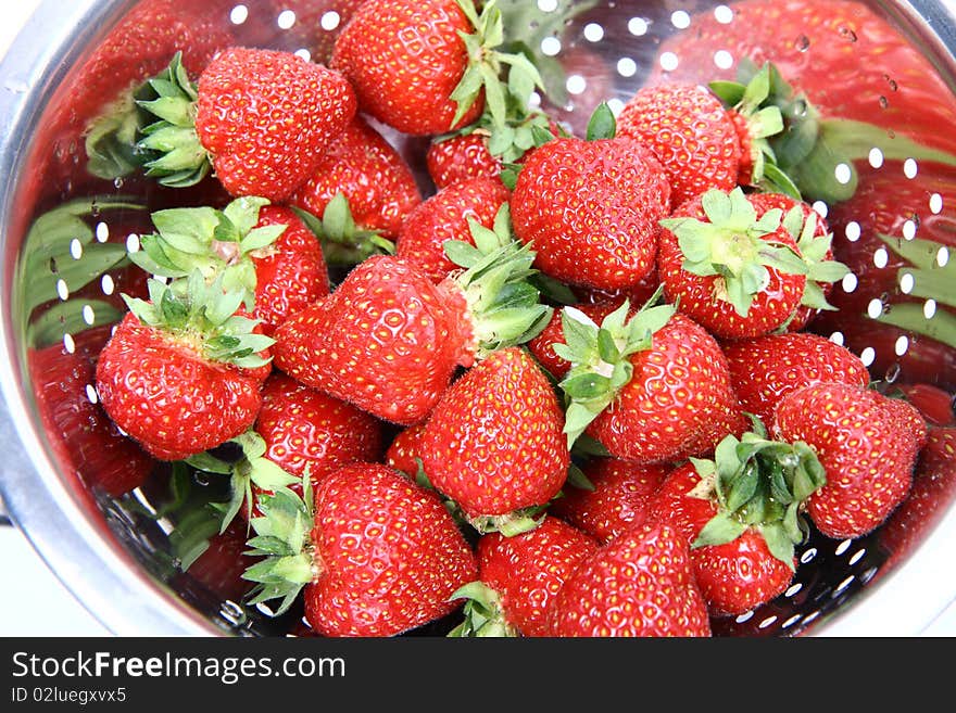 Fresh strawberries in a colander in close up