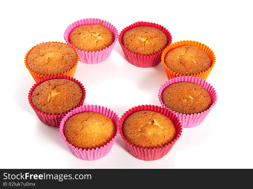 Colorful baked cupcakes in a circle isolated over a white background