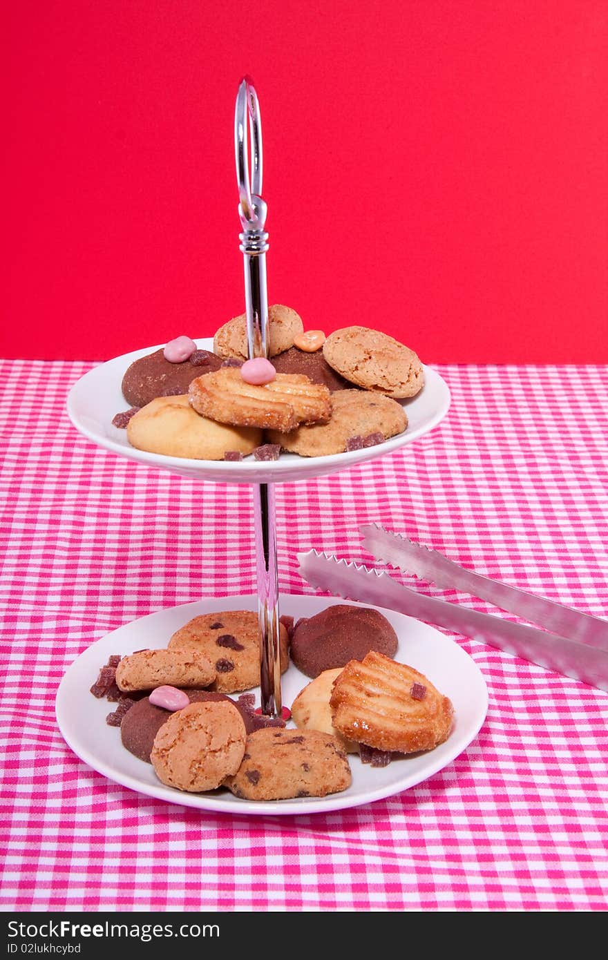 A serving bowl with sweets and cookies for a high tea on a colorful background. A serving bowl with sweets and cookies for a high tea on a colorful background