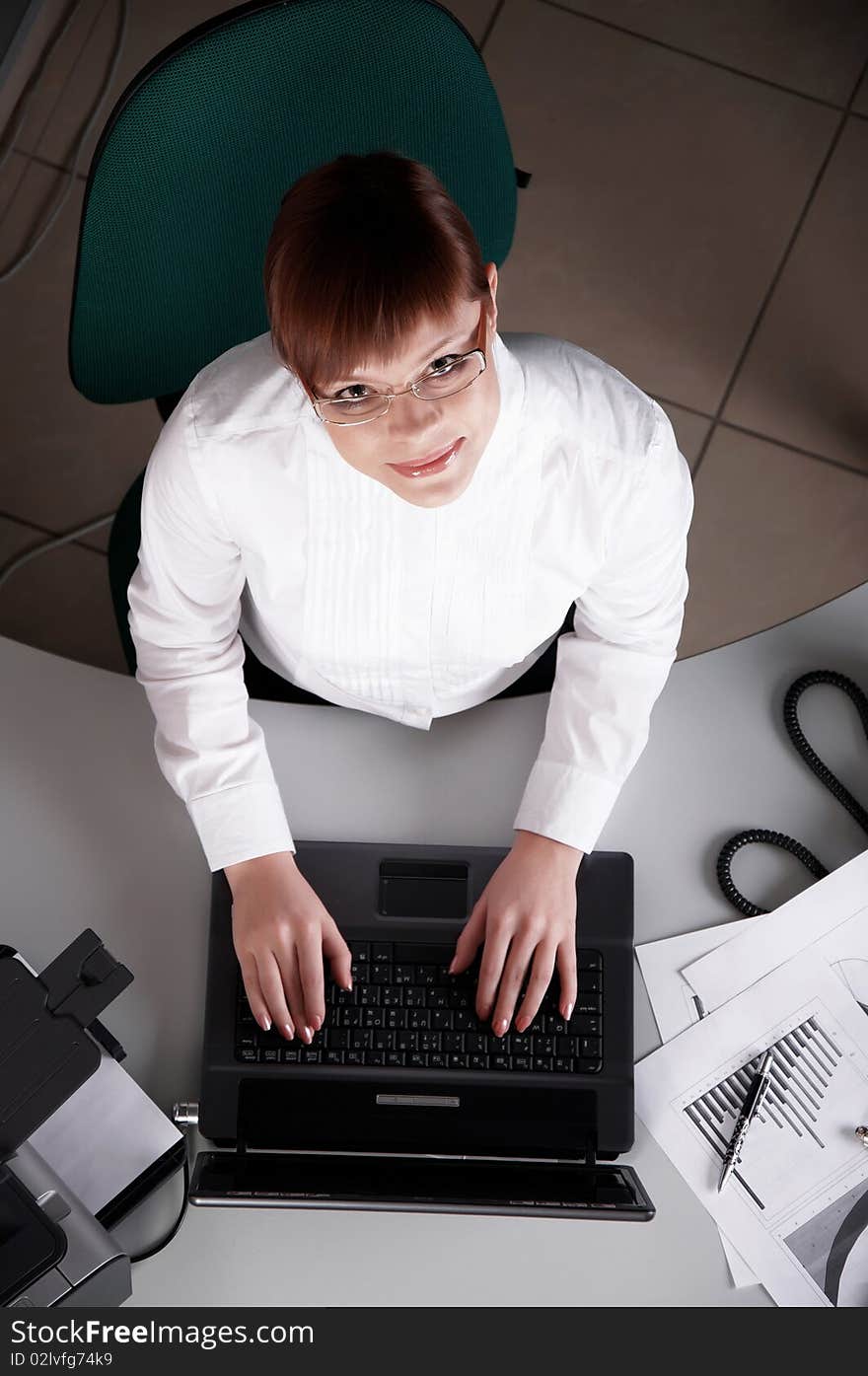 Young business woman working on a laptop at his desk in the office