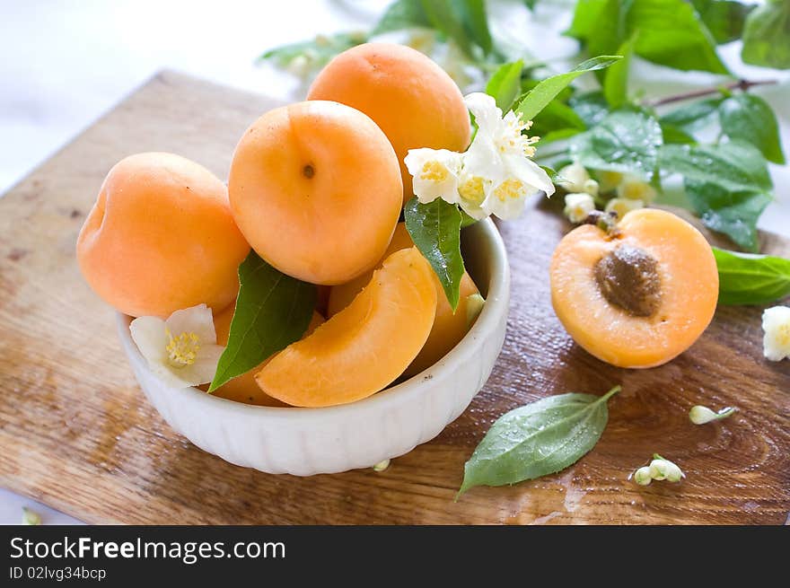 Fresh apricots in bowl on table